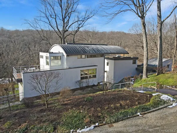 a view of a house with a yard and large tree