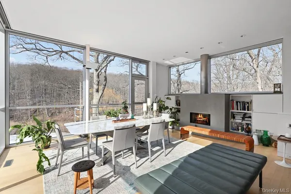 a living room with furniture a large window and wooden floor