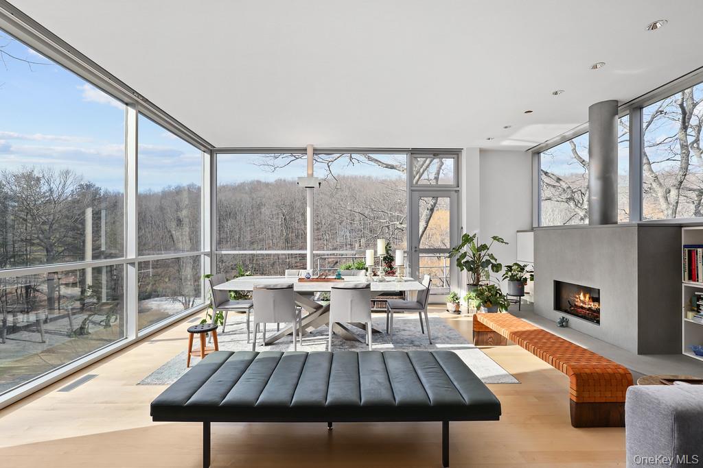 54 Cross Pond Road Pound Ridge, NY 10576 - Photo 8 of 50 a living room with furniture a fireplace and a floor to ceiling window