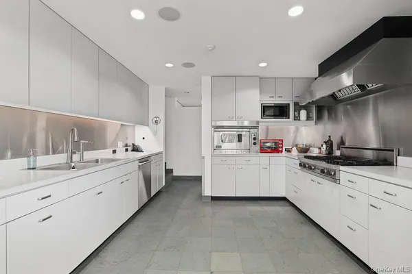 a kitchen with granite countertop white cabinets and white stainless steel appliances