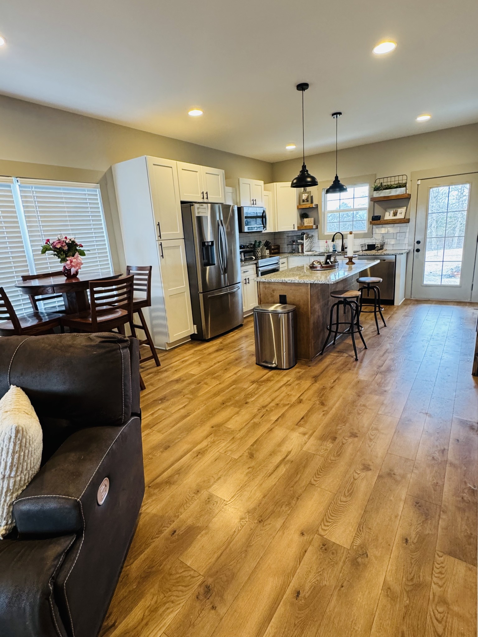 319 Lear Road Portland, TN 37148 - Photo 14 of 32 a kitchen with stainless steel appliances kitchen island granite countertop a refrigerator a stove a sink a dining table and chairs with wooden floor