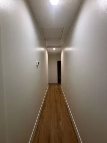 a view of a hallway with wooden floor