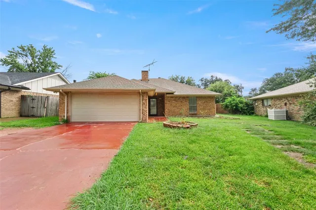a front view of a house with a garden and yard
