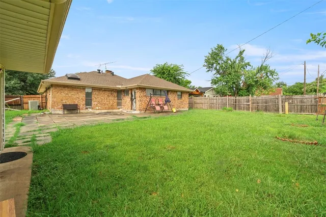 a view of a house with a big yard and potted plants