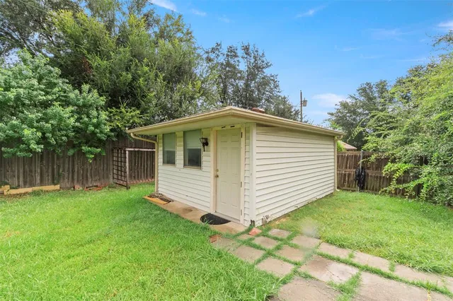a view of a backyard with plants and large trees