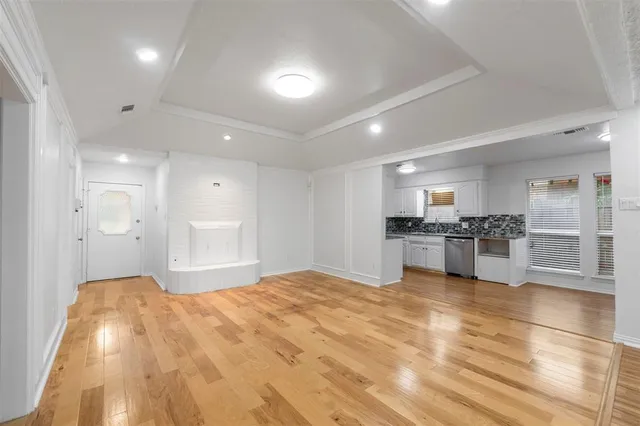 a large white kitchen with kitchen island a sink stainless steel appliances and cabinets