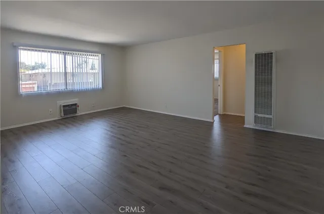 a large kitchen with a wooden floor and stainless steel appliances