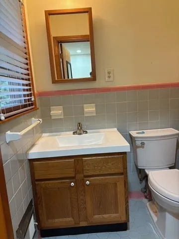a bathroom with a sink a toilet and mirror