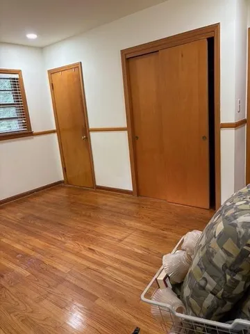 a view of a bedroom with wooden floor