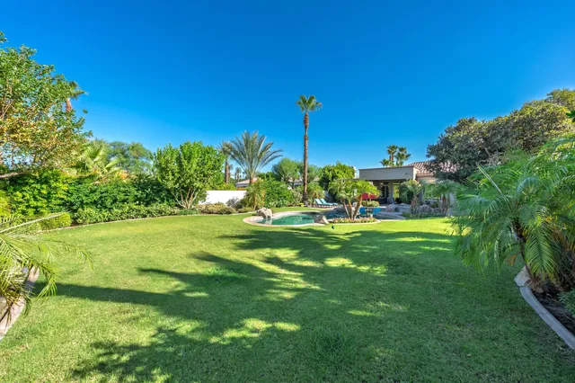 a view of yard with swimming pool and green space