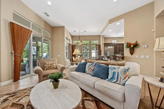 a living room with furniture fireplace and a large window