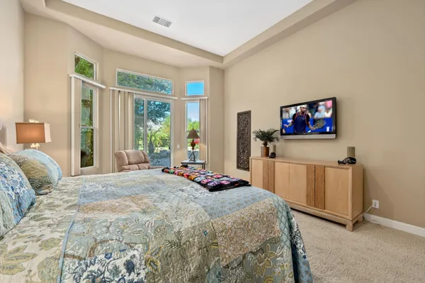 a bedroom with a bed a dresser and next to a window