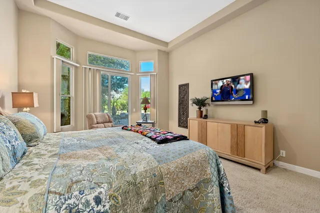 a bedroom with a bed a dresser and next to a window
