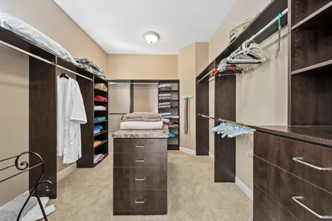 a view of walk in closet with clothes and shoes