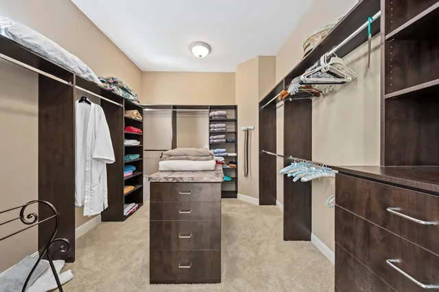 a view of walk in closet with clothes and shoes