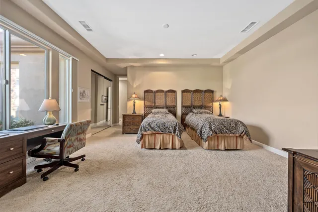 a bedroom with two beds and a large window