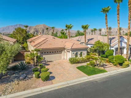 a front view of a house with a yard and mountain view