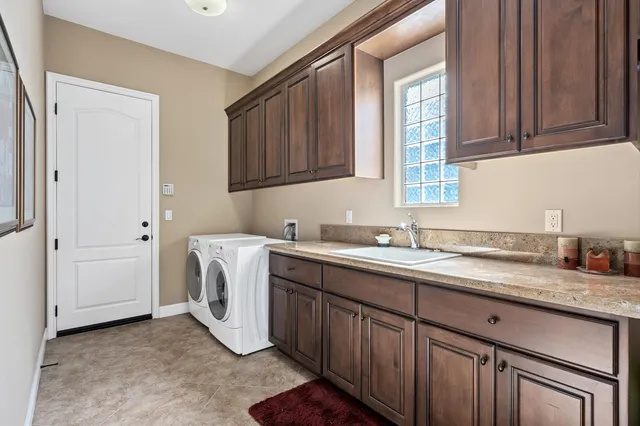 a utility room with cabinets washer and dryer