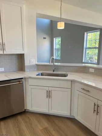 a kitchen with granite countertop white cabinets and a sink