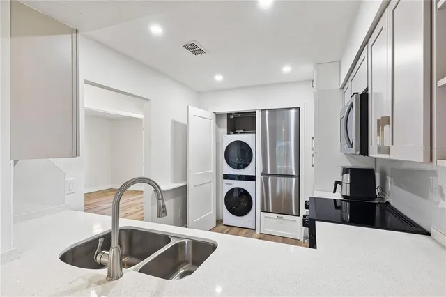 a kitchen with stainless steel appliances granite countertop a sink and a refrigerator