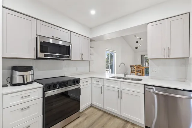 a kitchen with a sink stove and microwave