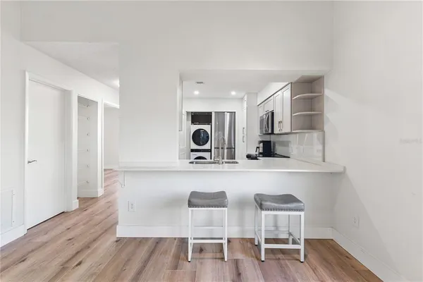 a large white kitchen with wooden floors and wooden cabinets