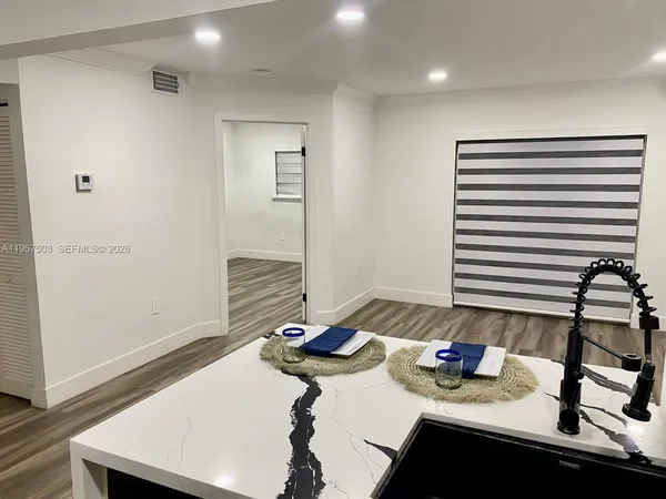 a room with a table chairs and wooden floor