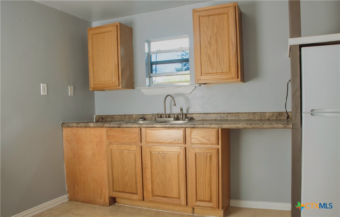 1407 South 7th Street Temple, TX 76504 - Photo 33 of 36 a bathroom with a granite countertop sink and a mirror