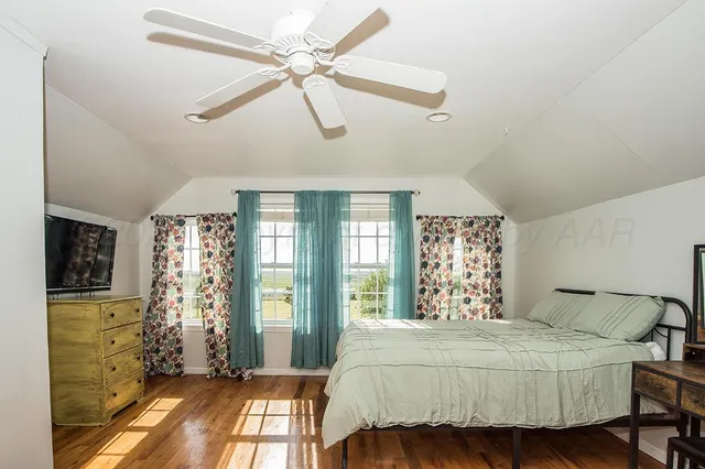 a bedroom with a large bed and a chandelier fan