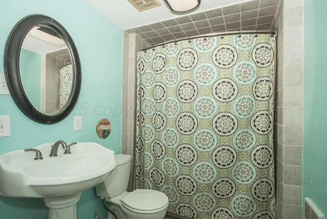 a bathroom with a toilet sink and mirror