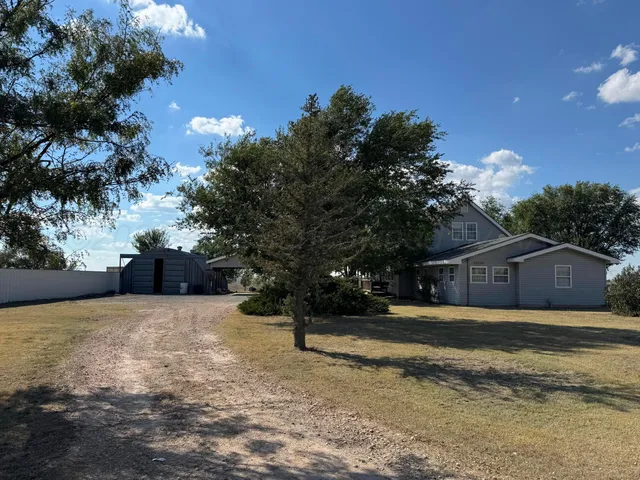 a view of a yard with a house in the background