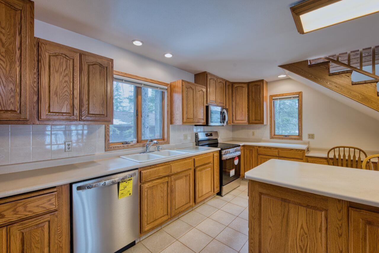 6312 Juniper Lane Gilbert, MN 55741 - Photo 12 of 50 Kitchen with a sink, tasteful backsplash, appliances with stainless steel finishes, and brown cabinets