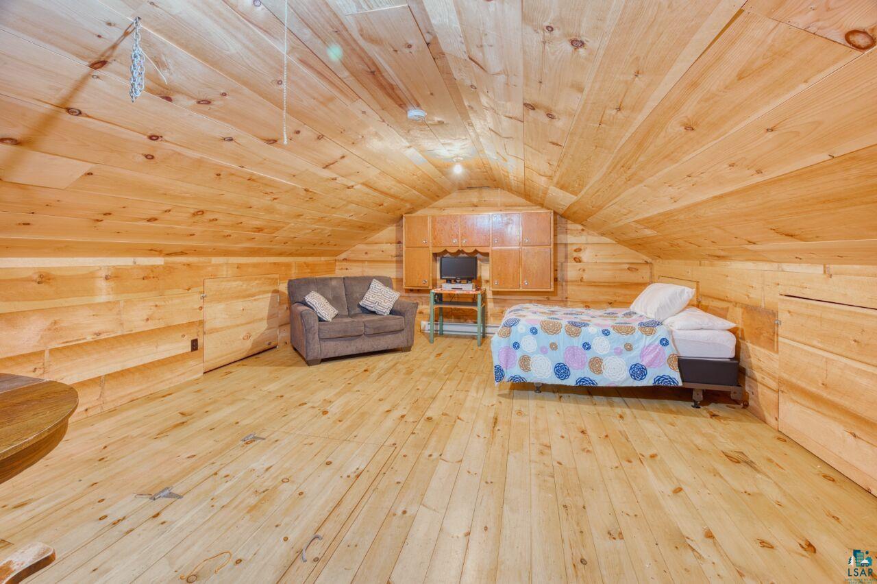 6312 Juniper Lane Gilbert, MN 55741 - Photo 33 of 50 Unfurnished bedroom featuring wood ceiling, light hardwood / wood-style flooring, vaulted ceiling, and wood walls