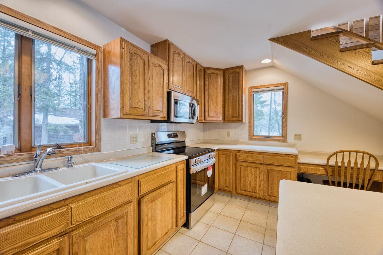6312 Juniper Lane Gilbert, MN 55741 - Photo 8 of 50 Kitchen featuring light tile patterned floors, light countertops, a sink, stainless steel appliances, and backsplash