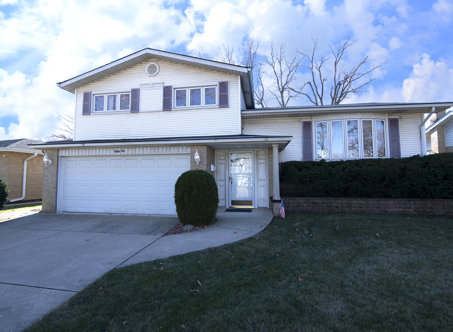 a front view of a house with a garden and yard