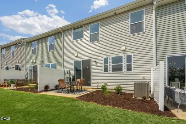 a view of a house with backyard and a tree
