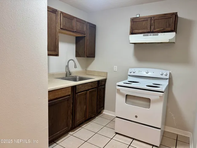 a kitchen with a sink cabinets and a wooden floor