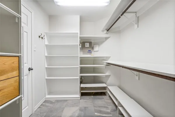 a view of walk in closet with empty racks