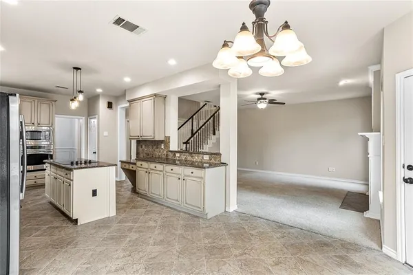a large kitchen with stainless steel appliances kitchen island granite countertop a sink and cabinets