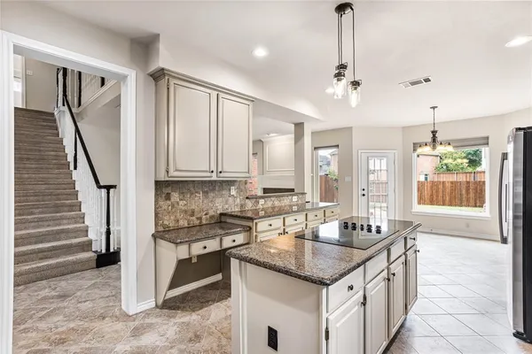 a kitchen with granite countertop a sink a counter top space appliances and cabinets