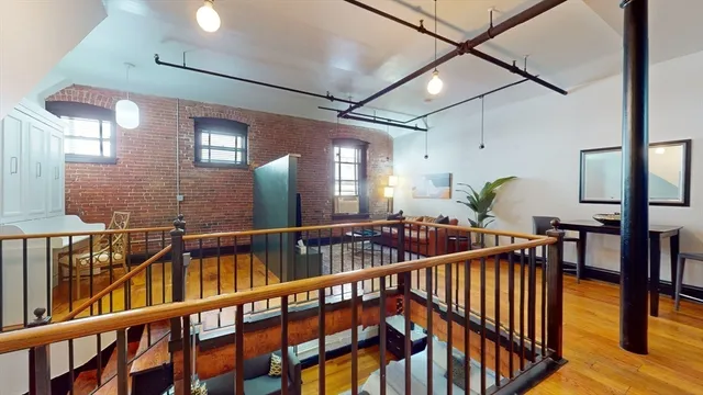 a view of staircase and living room with wooden floor