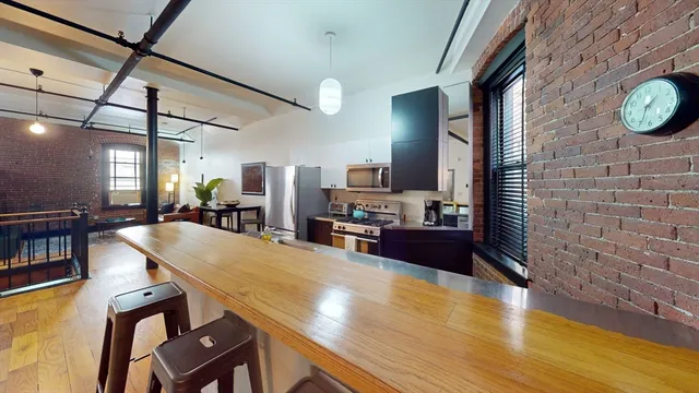 a kitchen with stainless steel appliances wooden floor dining table and chairs