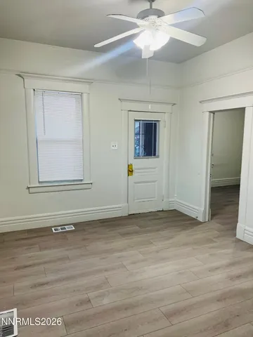 a view of a livingroom with wooden floor and a ceiling fan