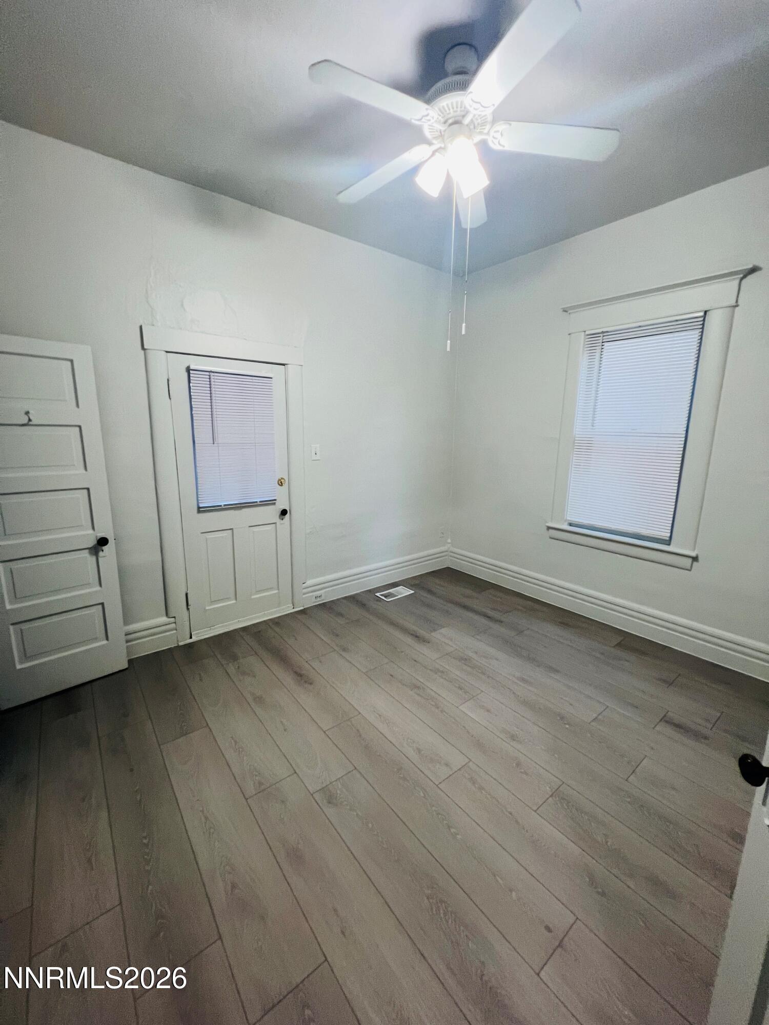 330 Stewart Street Reno, NV 89502 - Photo 10 of 21 an empty room with wooden floor chandelier fan and windows