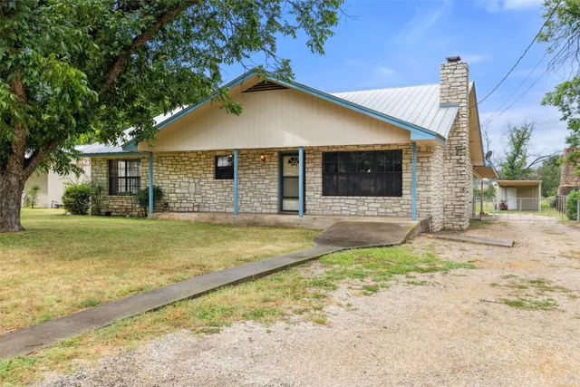a view of a house with a yard and sitting area