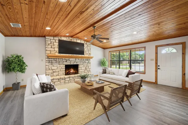 a living room with furniture a flat screen tv and a fireplace