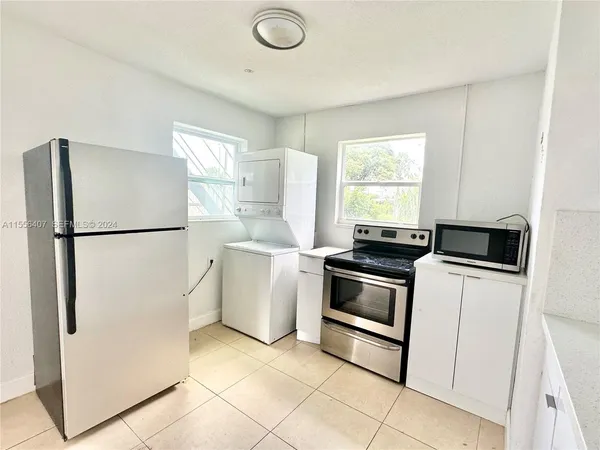a kitchen with a refrigerator a stove a washer and dryer
