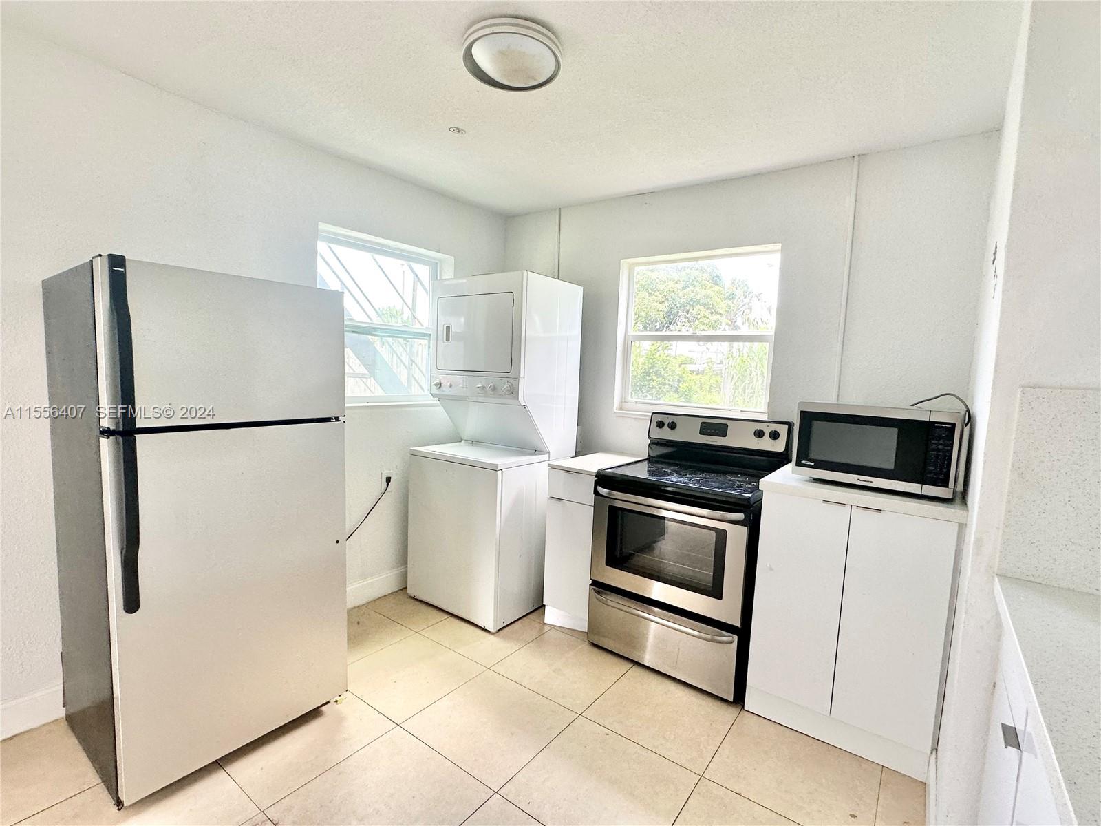 3730 S Avenue South, Unit 1 Riviera Beach, FL 33404 - Photo 2 of 12 a kitchen with a refrigerator a stove a washer and dryer