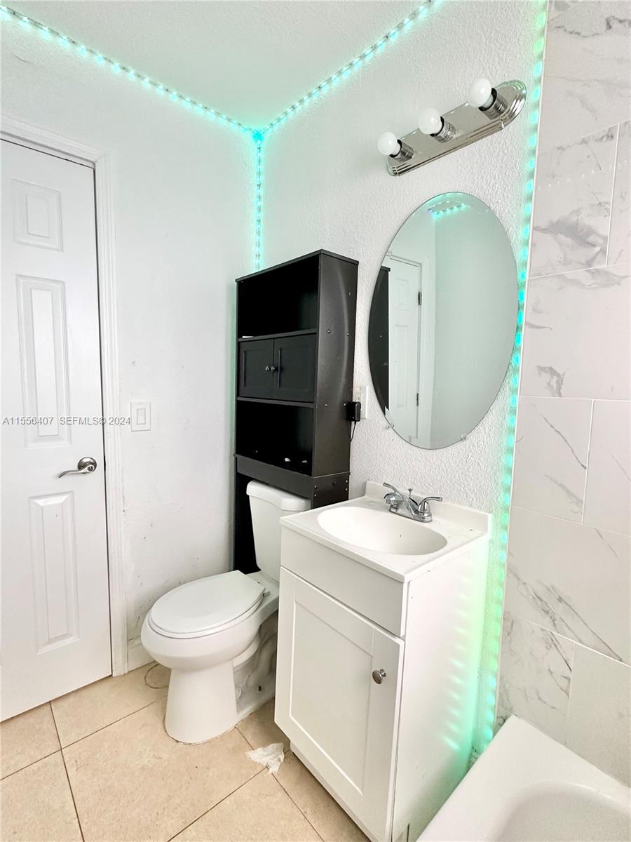 3730 S Avenue South, Unit 1 Riviera Beach, FL 33404 - Photo 4 of 12 a bathroom with a toilet sink and mirror