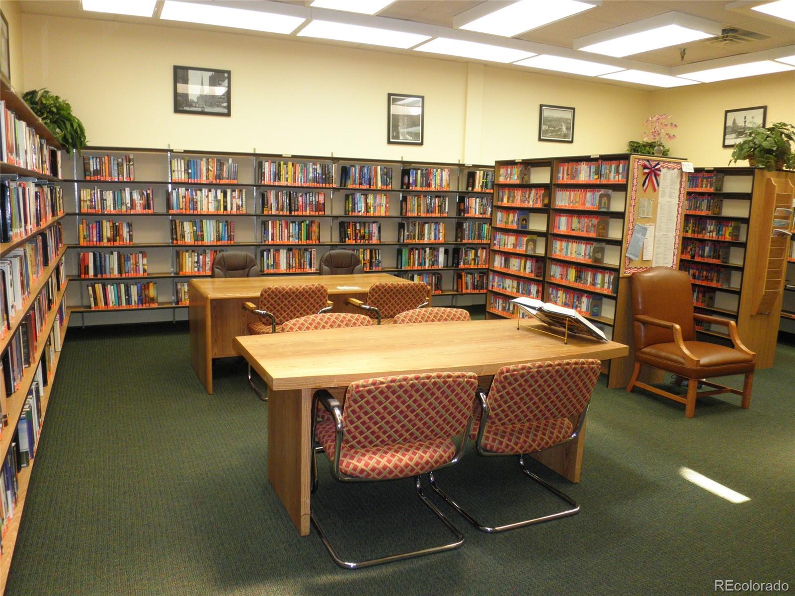9155 Center Avenue, Unit 9B Denver, CO 80247 - Photo 27 of 35 a room with a table chairs and a book shelf